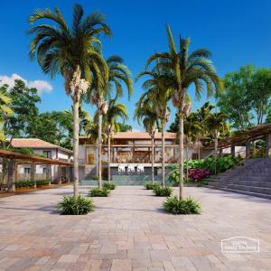 a courtyard with palm trees in front of a building at Quinta Santa Bárbara Eco Resort in Pirenópolis