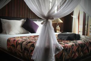 um quarto com uma cama e uma rede mosquiteira em BINTANG MUNDUK em Munduk