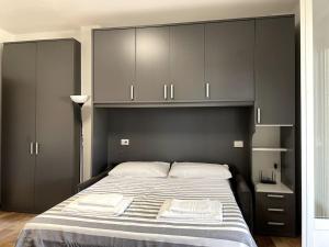 een slaapkamer met een groot bed en grijze kasten bij [FREE PARKING] il terrazzino ⭑⭑⭑⭑⭑ in Milaan