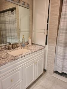 a bathroom with a sink and a mirror at Large Waterfront Modern Beach House in East Haven