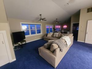 a living room with a couch and a tv at Large Waterfront Modern Beach House in East Haven