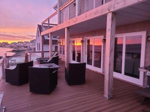 a deck with chairs and tables on a house at Large Waterfront Modern Beach House in East Haven