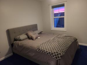 a bed in a bedroom with a window at Large Waterfront Modern Beach House in East Haven