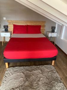1 dormitorio con 1 cama roja y 2 mesitas de noche en La buena vida, en Pointe-Noire