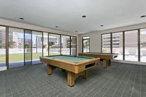 two pool tables in a room with windows at Royal Kuhio 1702 - Spacious Studio with Stunning Mountain City Views in the Heart of Waikiki! in Honolulu