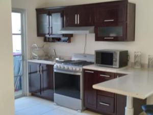 a kitchen with wooden cabinets and a stove top oven at CASA CERRITOS MAZATLAN in Mazatlán