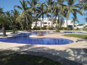 a swimming pool with palm trees in a resort at CASA CERRITOS MAZATLAN in Mazatlán