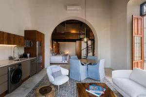 a kitchen and a living room with a table and chairs at Las Lupitas Hotel Boutique in Campeche