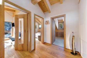 a living room with wooden floors and a hallway with doors at Töniglerhof Apt Morgensonne in Trodena
