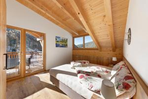 a bedroom with two beds and a balcony at Töniglerhof Apt Morgensonne in Trodena