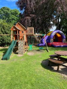un parque infantil con tobogán y estructura de juegos en Bennachie Lodge Hotel in Kemnay, en Inverurie