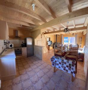 a kitchen and living room with a table and chairs at Chalet 6B dans les Pyrénées proche d'Andorre in LʼHospitalet-près-lʼAndorre