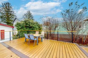 a wooden deck with a table and chairs on it at Bungalow by the Bay in Netarts