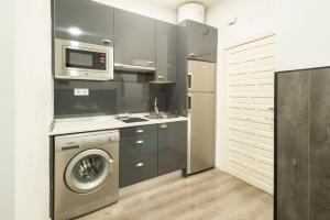 a kitchen with a washing machine and a microwave at Apartamentos Day Madrid PLAZA DE ESPAÑA Centro Gran Via Sol Malasaña in Madrid