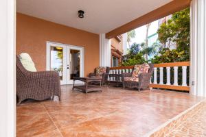 a porch with chairs and a couch on a balcony at Lighthouse Beach Villas in San Pedro