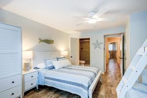 a white bedroom with a bed and a ceiling fan at Surf Court Villas 5 in Hilton Head Island