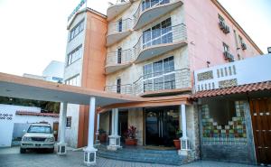 a building with a car parked in front of it at Brisotel - Beira Mar in Luanda