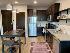 a kitchen with wooden cabinets and a stainless steel refrigerator at Flexhome Brown Deer 1BR Apt G1 - READ INFO in Brown Deer