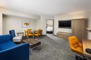 a hotel room with a living area with a table and chairs at Holiday Inn Express Hotel & Suites Port St. Lucie West by IHG in Port Saint Lucie