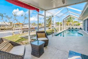 a patio with chairs and a swimming pool at Norma on the Canal in Punta Gorda