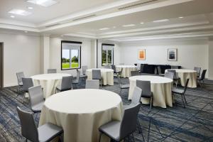 a conference room with tables and chairs in a room at Holiday Inn Express Hotel & Suites Port St. Lucie West, an IHG Hotel in Port Saint Lucie