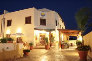 a white building with a clock on the side of it at Residence Hotel Marino Tourist in San Vito lo Capo