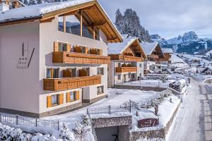 un complejo en las montañas con nieve en el suelo en Hotel Vernel en Santa Cristina in Val Gardena