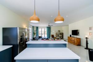 a kitchen with two pendant lights and a kitchen island at Turibana 50 G in Noord