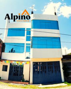 un edificio de búsqueda con un cartel en él en Alpino Guest House, en Huaraz