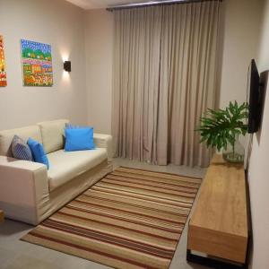 sala de estar con sofá blanco y almohadas azules en Quinta Santa Bárbara Eco Resort en Pirenópolis
