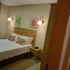 ein Schlafzimmer mit einem Bett mit zwei Kissen und einem Tisch in der Unterkunft Quinta Santa Bárbara Eco Resort in Pirenópolis