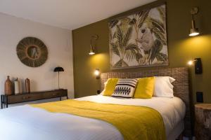a bedroom with a large bed with yellow pillows at Hôtel Le Patio - Deauville in Deauville
