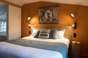 a bedroom with a large bed with orange walls at Hôtel Le Patio - Deauville in Deauville