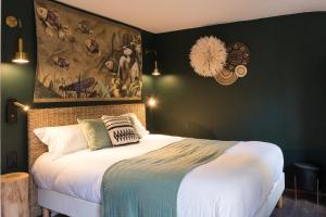 a bedroom with a bed with a painting on the wall at Hôtel Le Patio - Deauville in Deauville