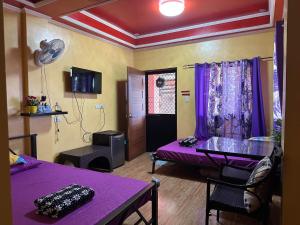 a room with a purple bed and a table at Vhauschild Transient Rooms -B in Alaminos