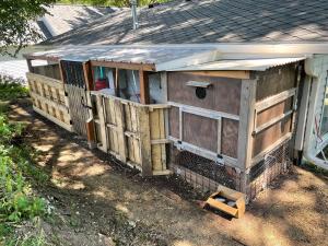 a wooden chicken coop sitting on the side of a house at Del Boca Vista in Owatonna