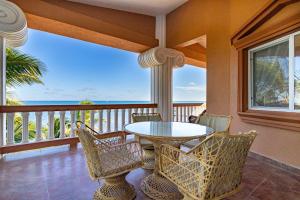 d'une table et de chaises sur un balcon donnant sur l'océan. dans l'établissement Lighthouse Beach Villas, à San Pedro