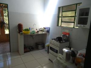 a small kitchen with a stove and a sink at Estalagem das Estrelas in Cristalina