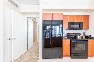 una cucina con frigorifero nero e forno a microonde di TRUMP INTL 2 BEDROOM APARTMENT 1600 Sf Ocean and Bay View With Terrace a Miami Beach Altre 70 foto