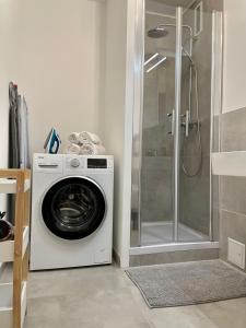 a washing machine in a bathroom with a shower at River Main I Taunus View I Workplace I Kitchen in Offenbach