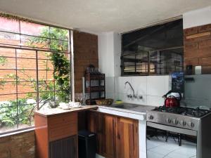 a kitchen with a stove and a stove top oven at Mountain Chalet - Tungurahua Hot Springs/Aguas Termales in Baños