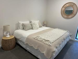 东南金斯顿White Hut on Golflinks的一间卧室配有一张带镜子的大床