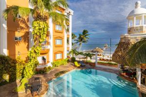 an image of a hotel with a swimming pool and a building at Lighthouse Beach Villas in San Pedro