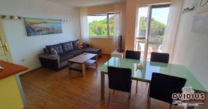 a living room with a table and a couch at Arode Villa Ovidius in Balchik