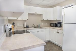 uma cozinha com armários brancos e um frigorífico branco em 4 Bedroom House by Leavetown Vacations em Superior