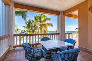 a balcony with a table and chairs and the ocean at Lighthouse Beach Villas in San Pedro