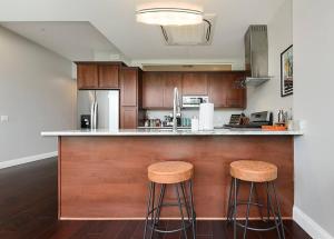 a kitchen with a counter with two stools at HostWise Stays - Free Garage Parking, Gym, City Views! in Pittsburgh