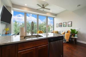 a kitchen with a sink and a large window at HostWise Stays - Free Garage Parking, Gym, City Views! in Pittsburgh