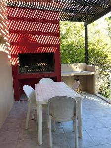 una mesa y sillas en un patio con parrilla en Rincon de las Pampas en Mar de las Pampas