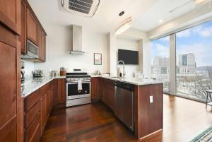 a large kitchen with wooden cabinets and a large window at HostWise Stays - The Washington at Chatham - Free Parking, Private Gym, Skyline Views! in Pittsburgh